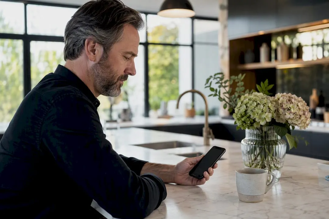 Hände, die ein Smartphone im Büro der Gastronomie halten
